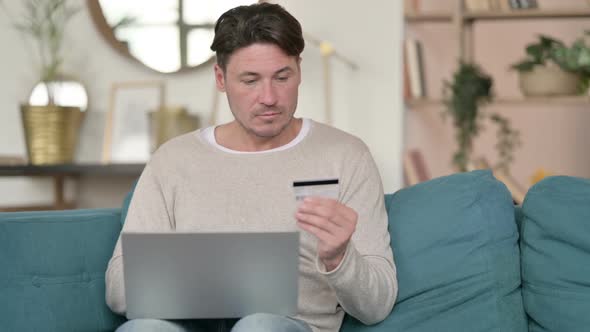 Online Shopping Payment on Laptop By Middle Aged Man at Home