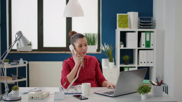 Female Secretary Using Landline Phone at Company Job