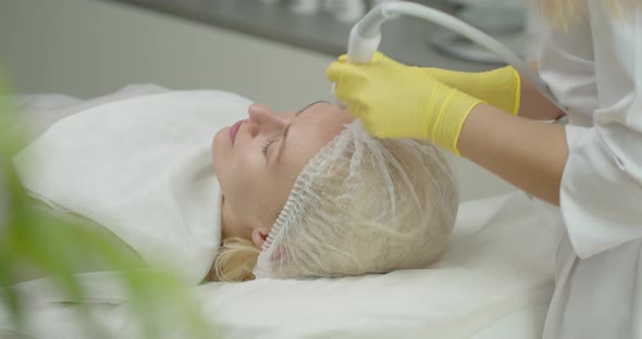 An Attractive Woman In A Beauty Clinic Receives A Procedure For Facial Skin. 