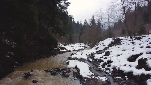 flying over the mountain river. winter forest. fog. aerial drone shot.