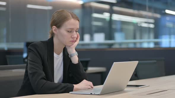 Sleepy Businesswoman Taking Nap While Using Laptop