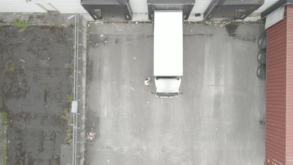 Delivery Truck Parked At The Loading Bay Of A Warehouse In Dublin, Ireland. Truck Driver Gets Off An