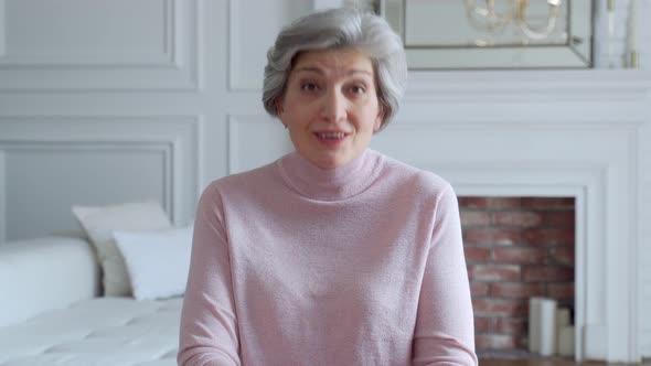 Cheerful Older Woman Looking Talking To Camera Conference Calling at Home. Grandmother Speak To