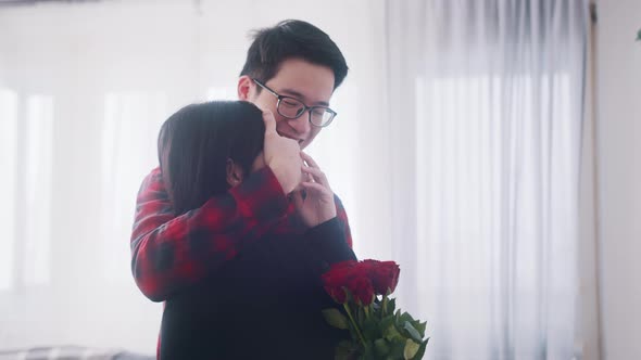 Young Asian Man Closing Eyes of His Girlfriend and Surprising Her with Red Roses for Anniversary