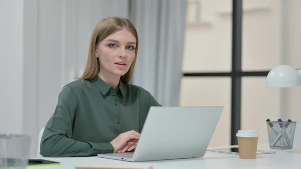 Young Woman with Laptop Smiling at Camera 