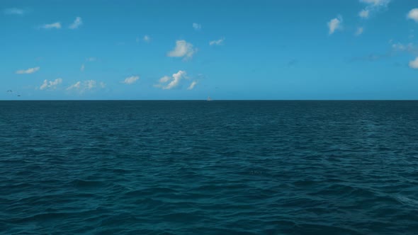 A Wake From a Ship at Sea with Blue Ocean Water a Horizon Blue Sky and Clouds