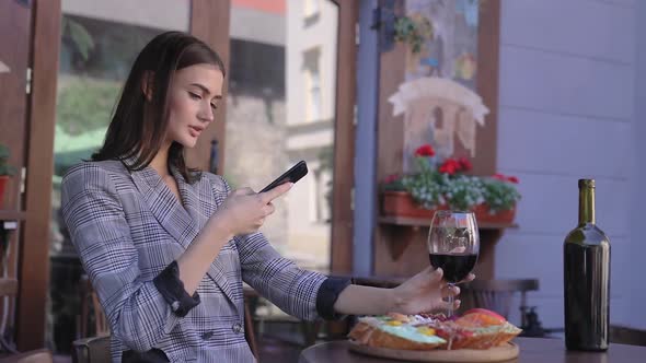 Beautiful Woman Taking Food Photos On Mobile Phone At Restaurant