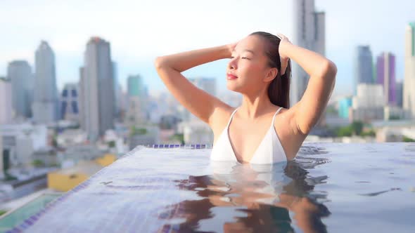 Young asian woman enjoy around outdoor swimming pool for leisure