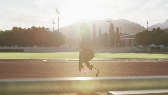 Disabled mixed race man with prosthetic legs walking on a race track