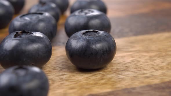 Blueberries stacked in rows on a wooden textured surface