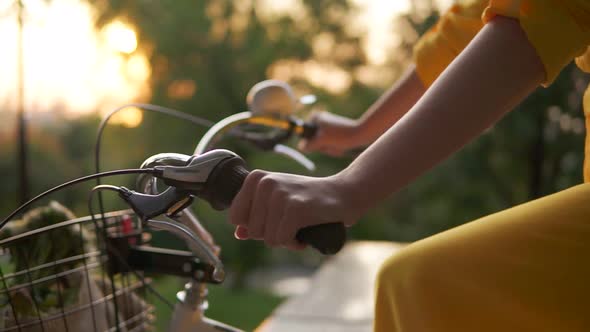 Closeup View of an Unrecognizable Woman's Hands Holding a Handlebar While Riding a City Bicycle with