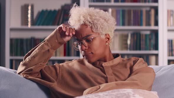 Young Worried Ethnic African American Woman Nervous Sits on Sofa