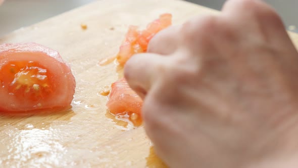 Cutting tomatoes on smaller pieces with knife close-up 4K 2160p UltraHD footage - Fresh tomatoe bein