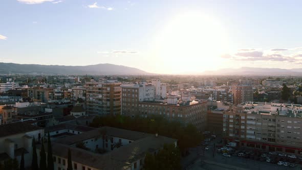 Drone shot rising over Murcia City in Spain at sunset with mountains