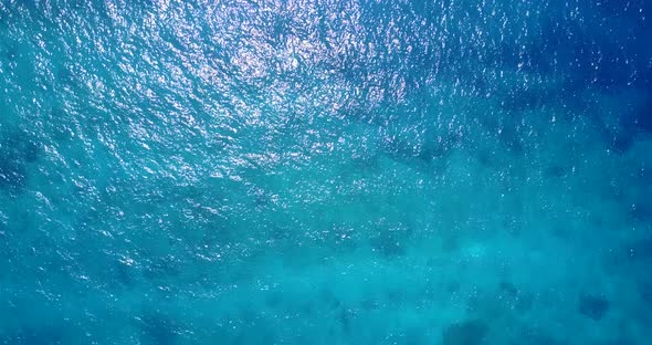 Natural overhead copy space shot of a white paradise beach and aqua blue ocean background in 4K
