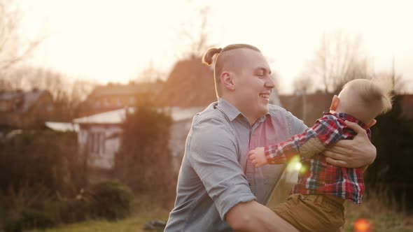 Young Father Playing with Little Son Outdoors