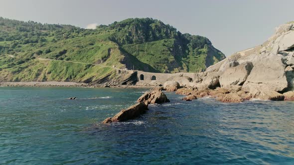 Wavy Waters Crashing Against Rocks and Gaztelugatxeko View in Background