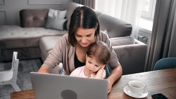 Female Parent Spending Time with Little Child Use Computer