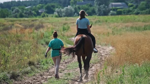 Back View Young Woman Riding Horse in Countryside Horseback Riding Slow Motion