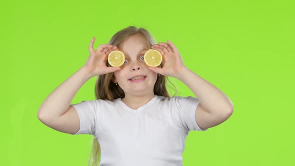 Kid Girl Closes Her Eyes with a Lemon and Shows Different Emotions, Licks It and Croaks. Green