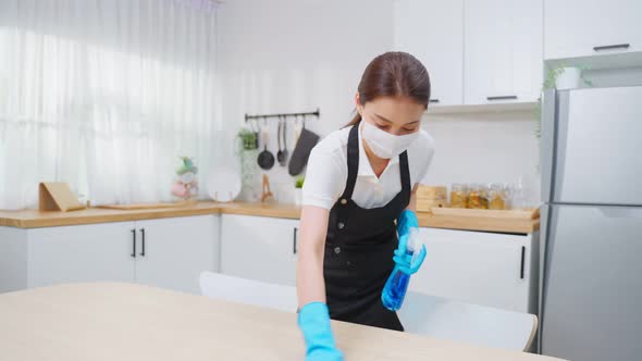 Asian active cleaning service woman worker cleaning in kitchen at home.