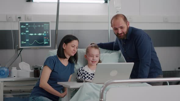 Family Sitting Beside Little Daughter Greeting Friends During Online Videocall Conference