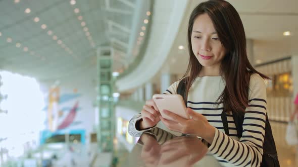 Woman text on smart phone in shopping plaza