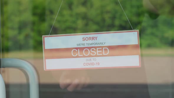 The Man Changes the CLOSED Sign for the OPEN Sign