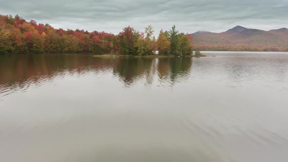 Aerial View of Colorful Foliage Trees on Small Island with Lake Water Surface