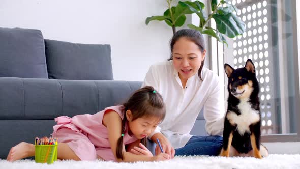 Mother and little daughter with their dog spending time together at home.