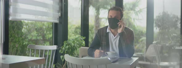 Man in empty cafe and having call