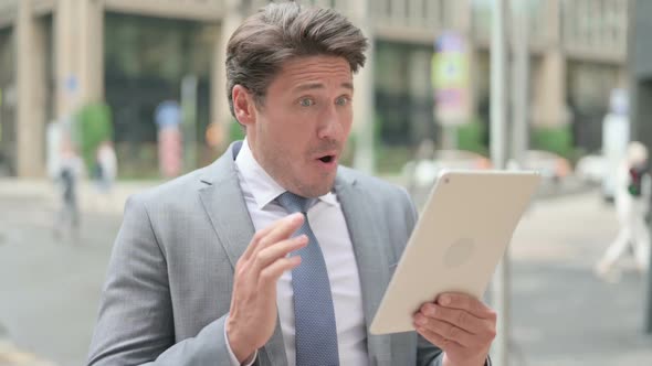 Middle Aged Businessman having Loss on Tablet Outdoor