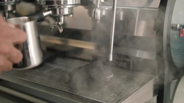 Slow mo close up of a puff of steam coming out of a cafe milk steamer. Usually used in the coffee ma