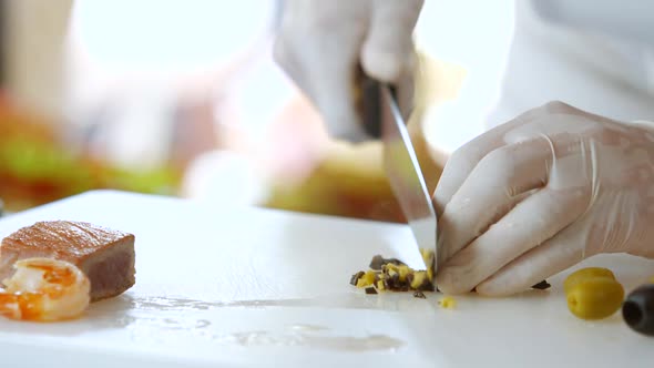 Hand with Knife Cutting Olive.