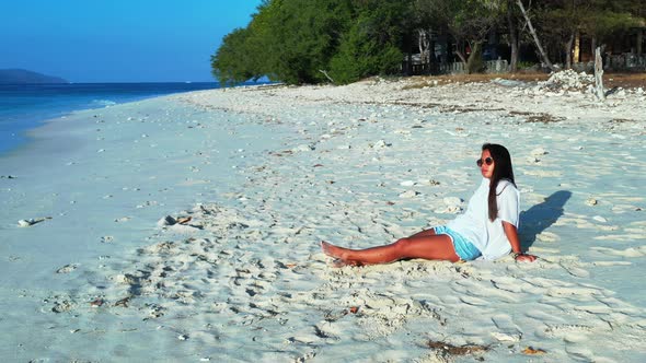 Pretty fun women on holiday in the sun on beach on sunny blue and white sand 4K background