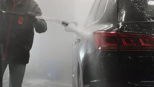 Make Worker Washing Black Car Arches Under High Pressure Water After Foam Application