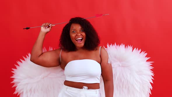 African Latin Cupid Woman in Wtite Top Bra Holding Bow and Arrow in Red Studio The 14Th of February