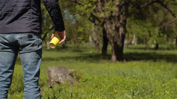 A Man Throws Out a Used Plastic Cup on Nature