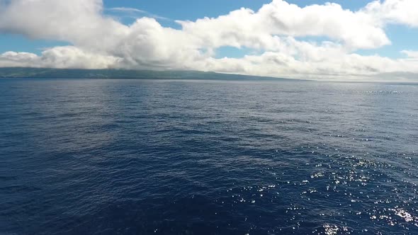 Short flight above the ocean with an island in the distance