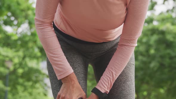 Senior woman in pain holding her leg in the park