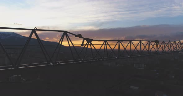 Silhouette of Construction Crane on Susnet with Colorful Clouds