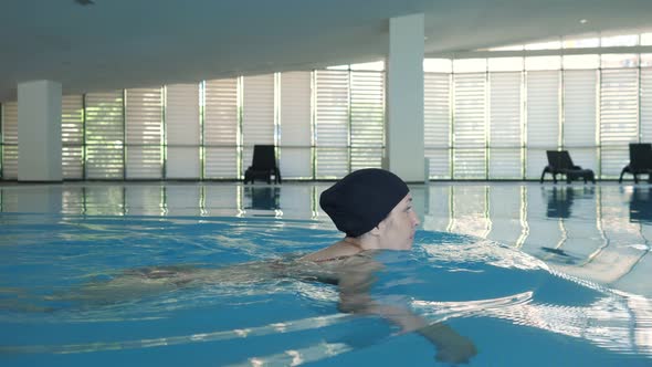 Young Woman Is Swimming Freestyle in Pool, Side View.