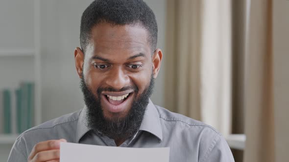 Happy Biracial Black Young Adult Male Receiving Letter Mail Paper Notice of Bank Loan Approval