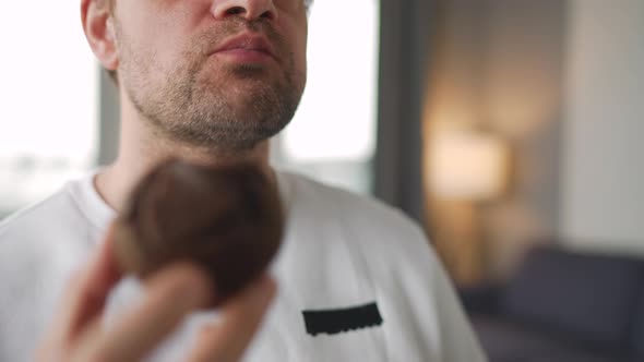 Man Eating Eating Chocolate Muffin and Drinking Tea