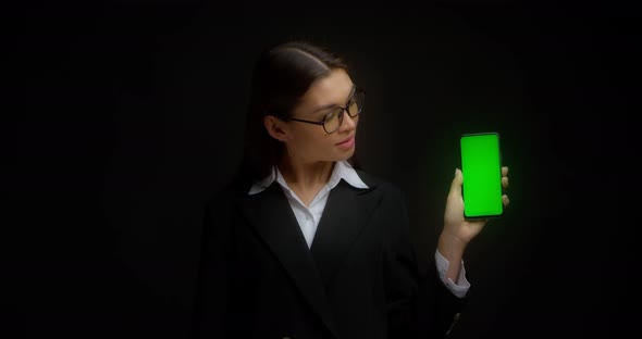 Business Lady in Glasses Shows Vertical Green Phone Screen for Copying