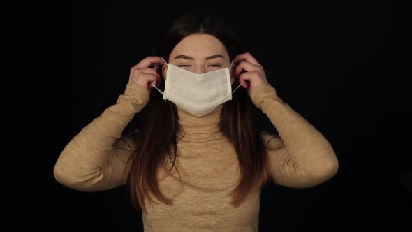 Charming Girl Putting on a Medical Protective Mask Against Coronavirus. Covid-19 Defense