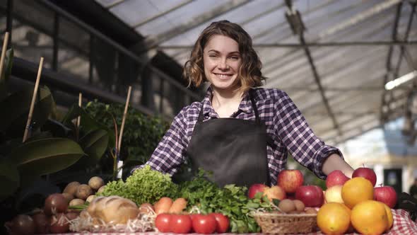 Portrait of Beautiful Shorthaired Smiling Woman Farmer Selling Organic Food in Farm Market Smiling