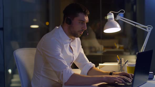 Businessman in Headset with Laptop at Night Office 18