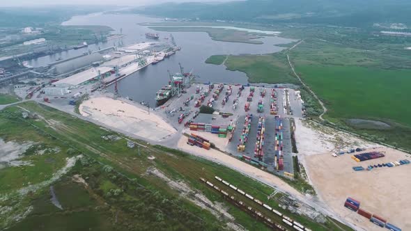 Aerial footage of port container terminal. Industrial cargo harbor with ships and cranes.