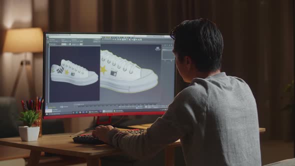 Asian Male Footwear Designer Rotate 3D Model Of Shoe While Working On A Desktop At Home